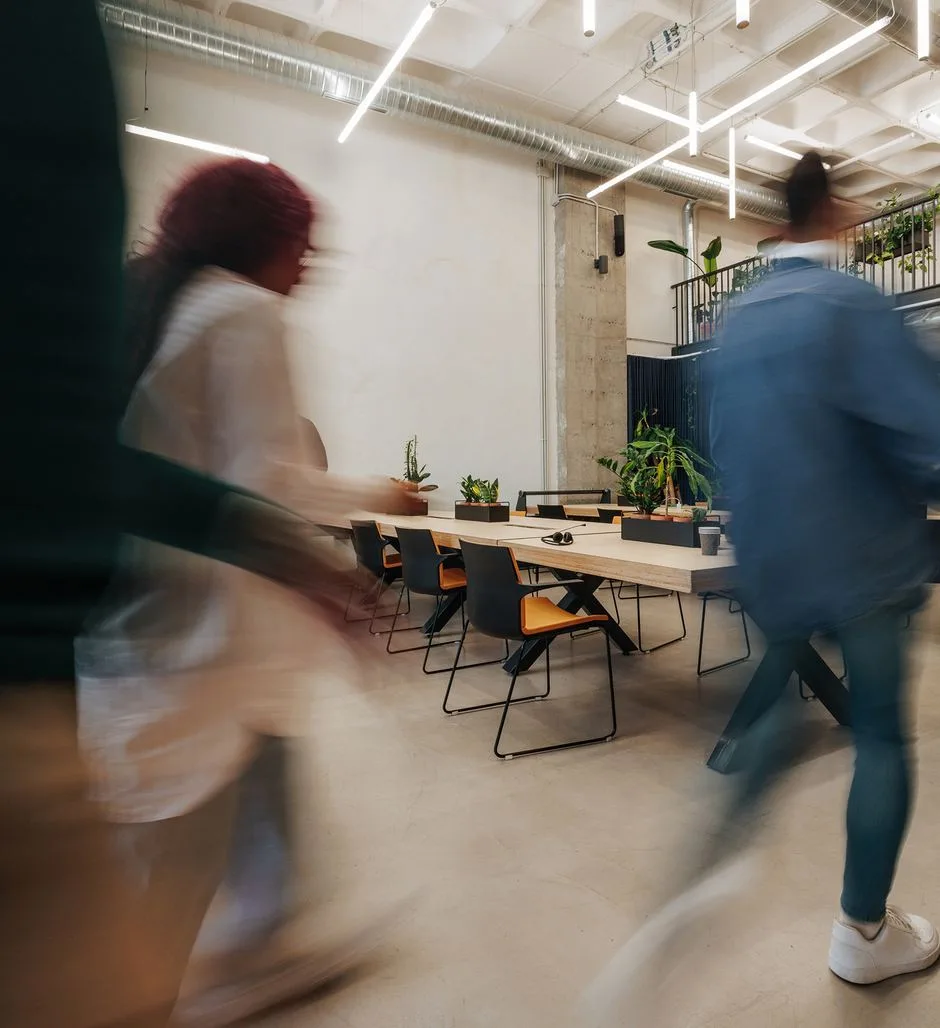 Two colleagues walking together through a bright office