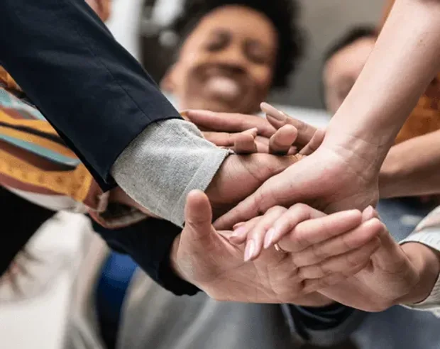 Colleagues stacking their hands together in a huddle